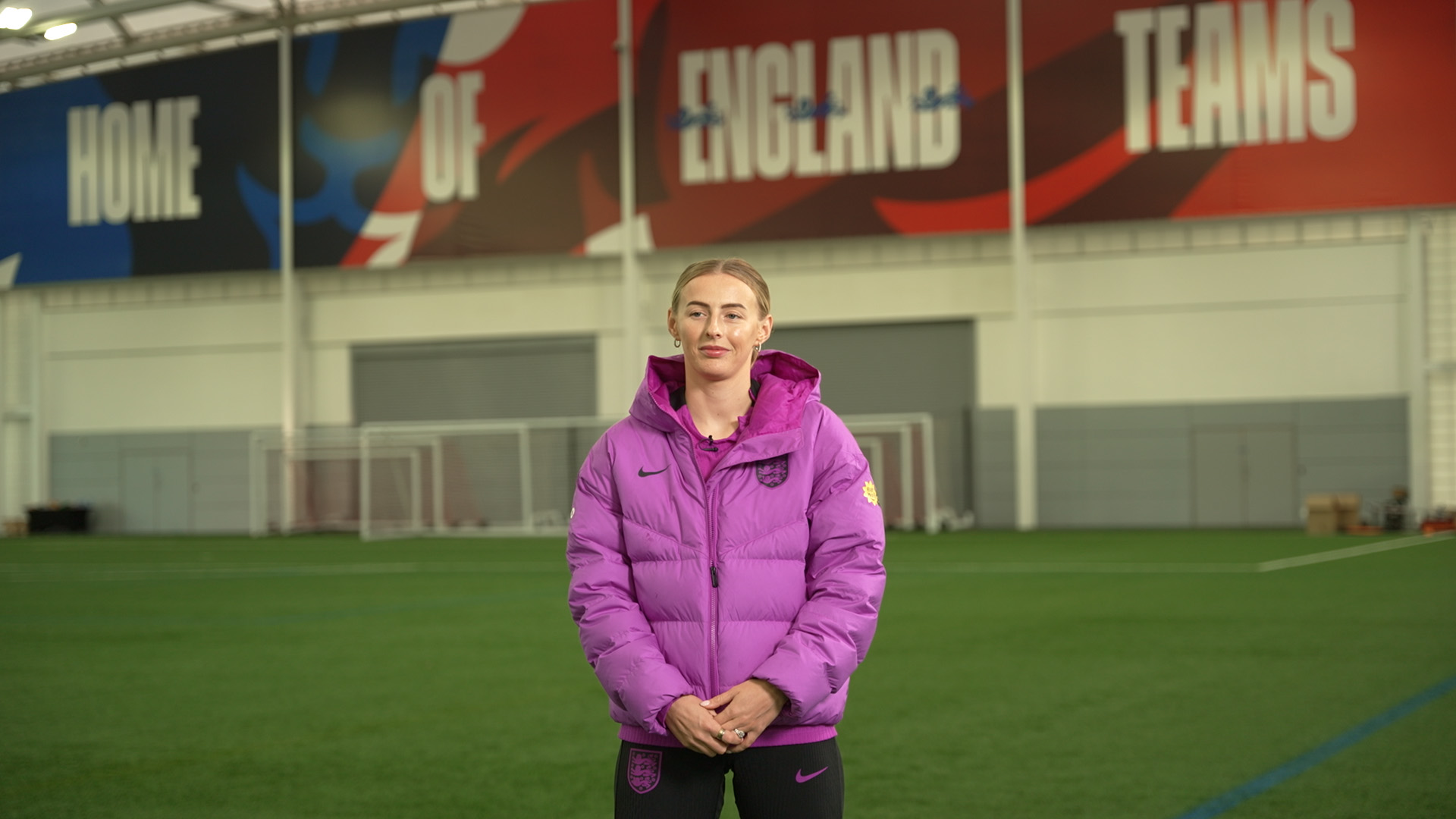 England player in purple jacket on indoor pitch